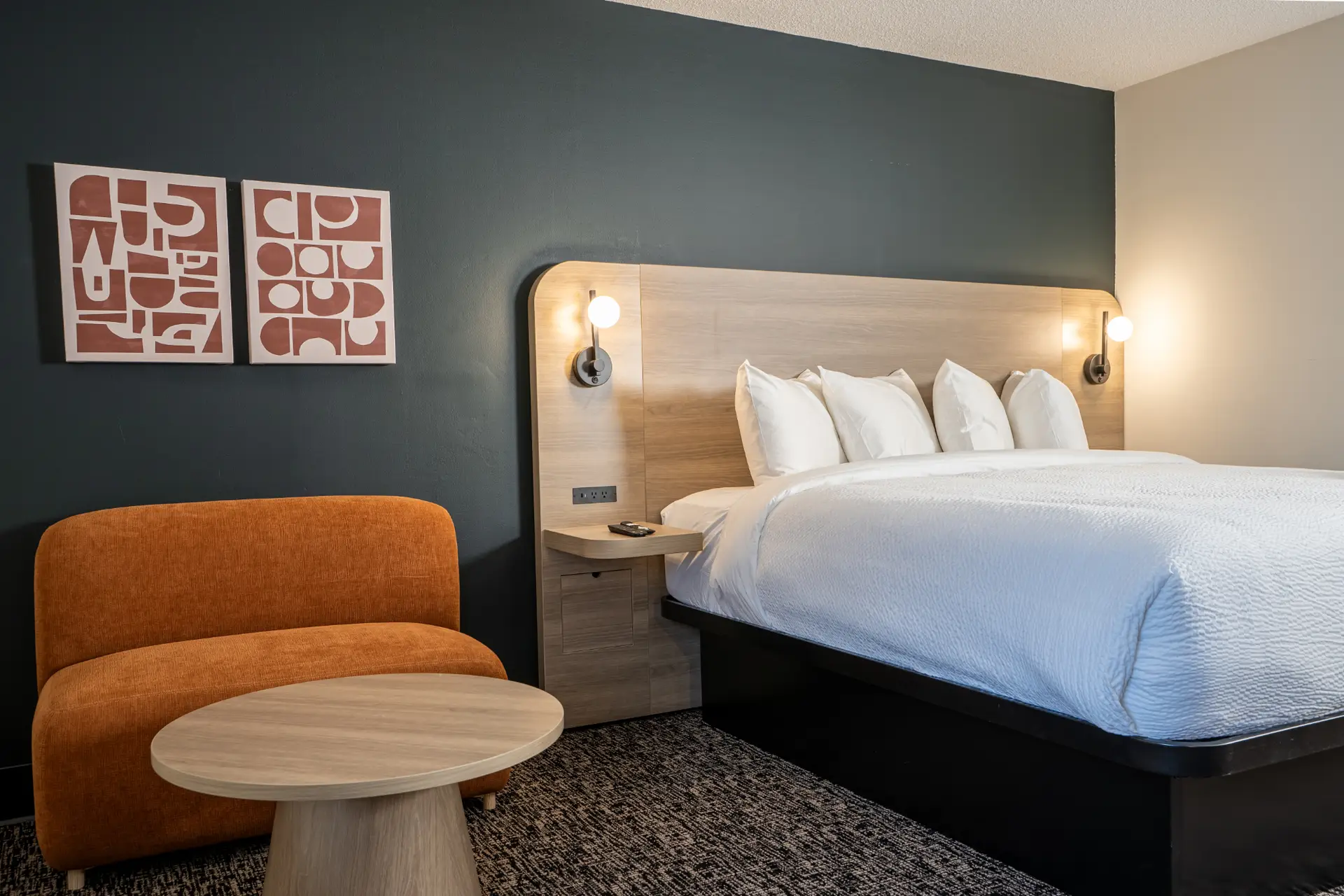 Basecamp Northwinds Revelstoke king room with orange chair and modern art.