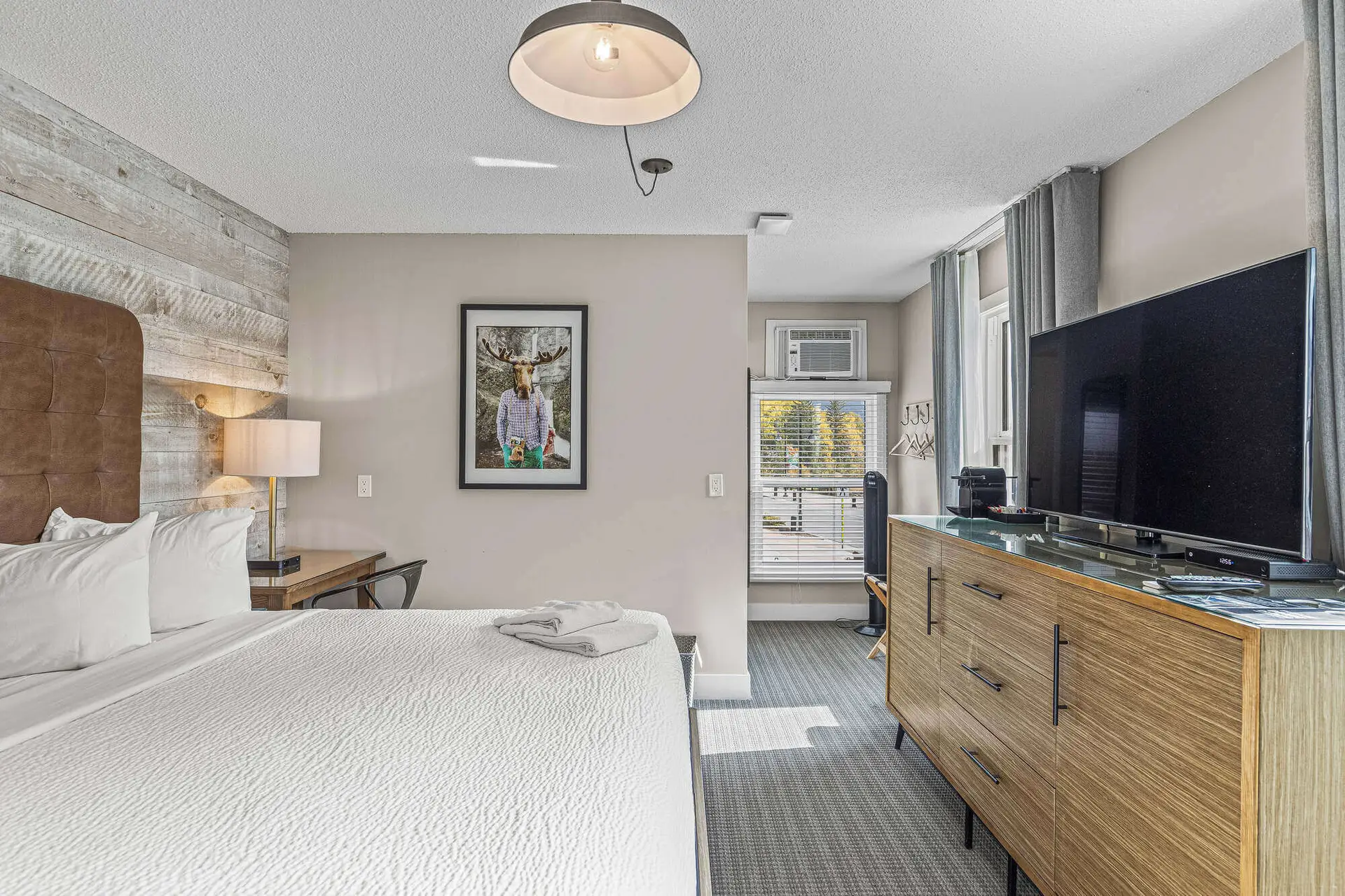 King bed in a modern hotel room at Basecamp Lamphouse, Canmore