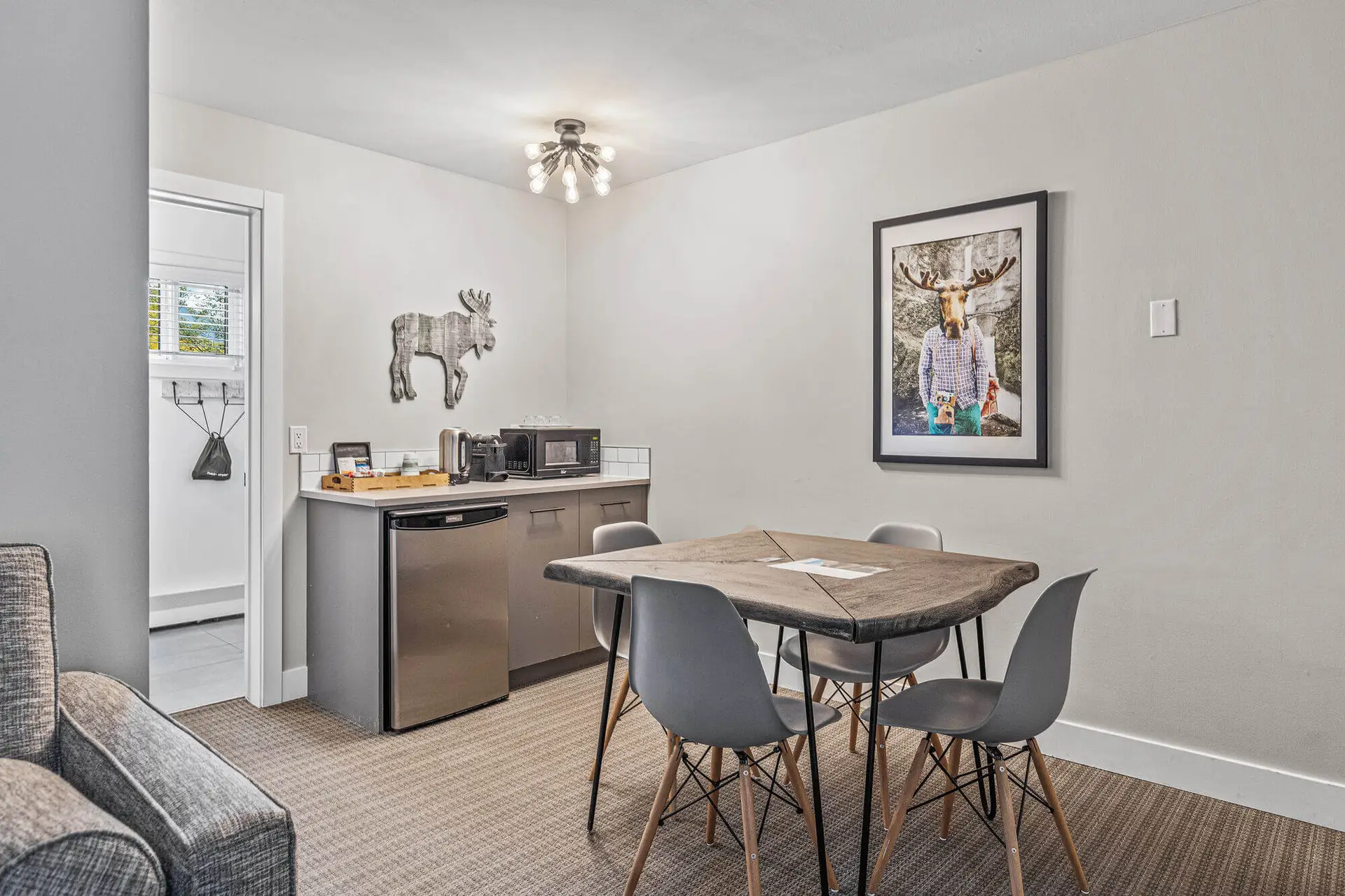 Basecamp Lamphouse Canmore Queen Suite kitchenette with dining table and moose art.