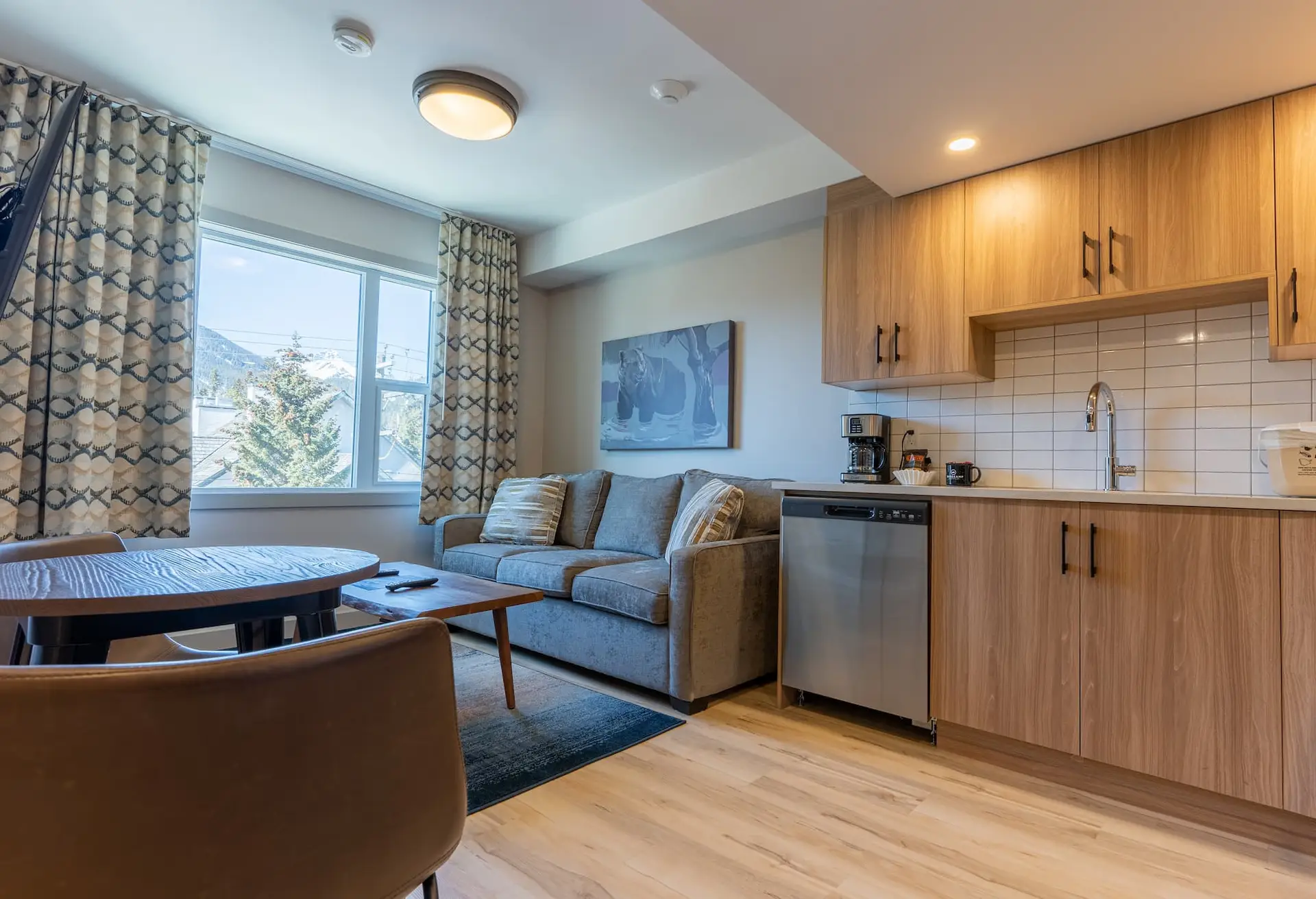 One bedroom suite at Basecamp Suites Banff with kitchen, living area, and mountain view.