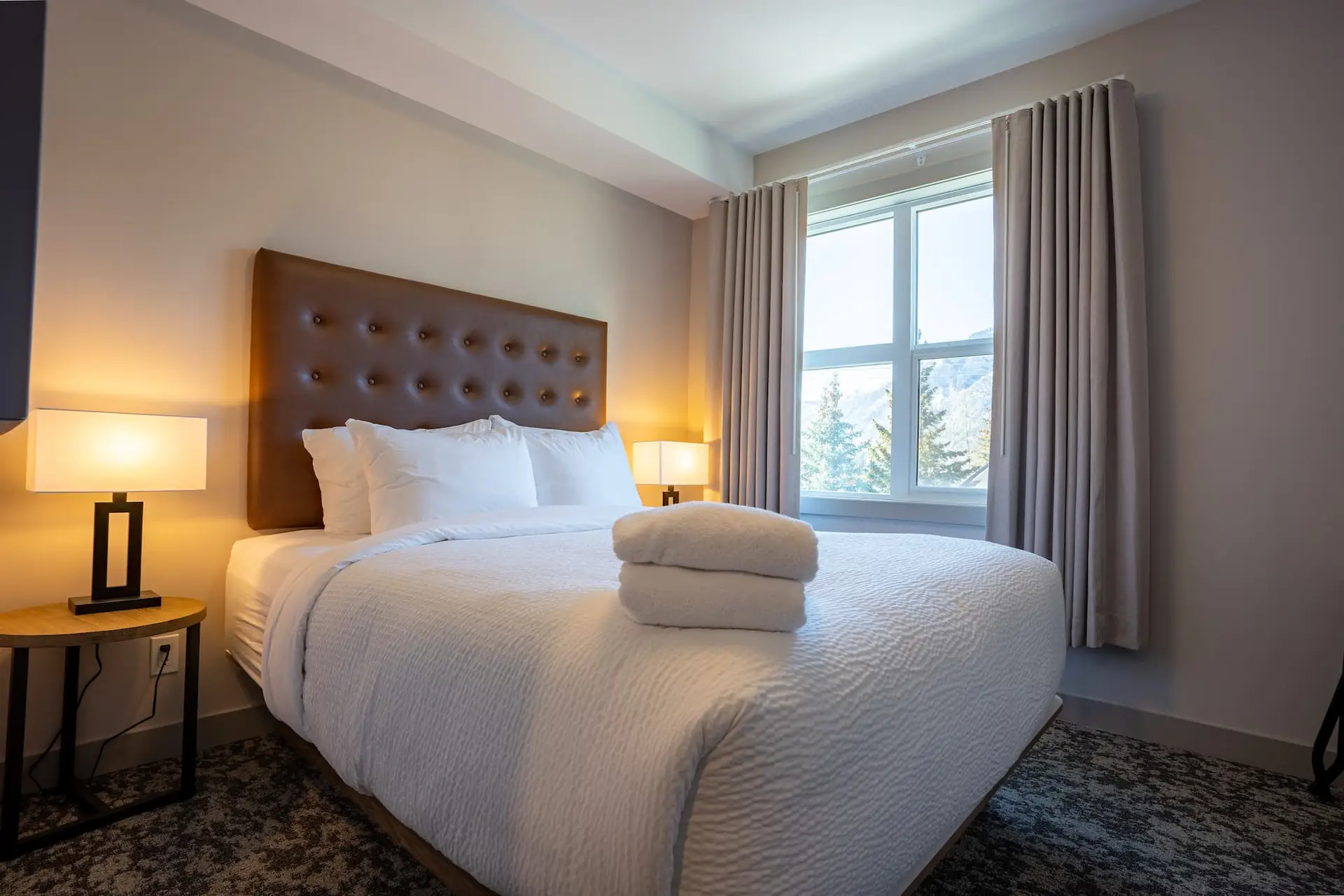 One bedroom suite at Basecamp Suites Banff with king bed and mountain view