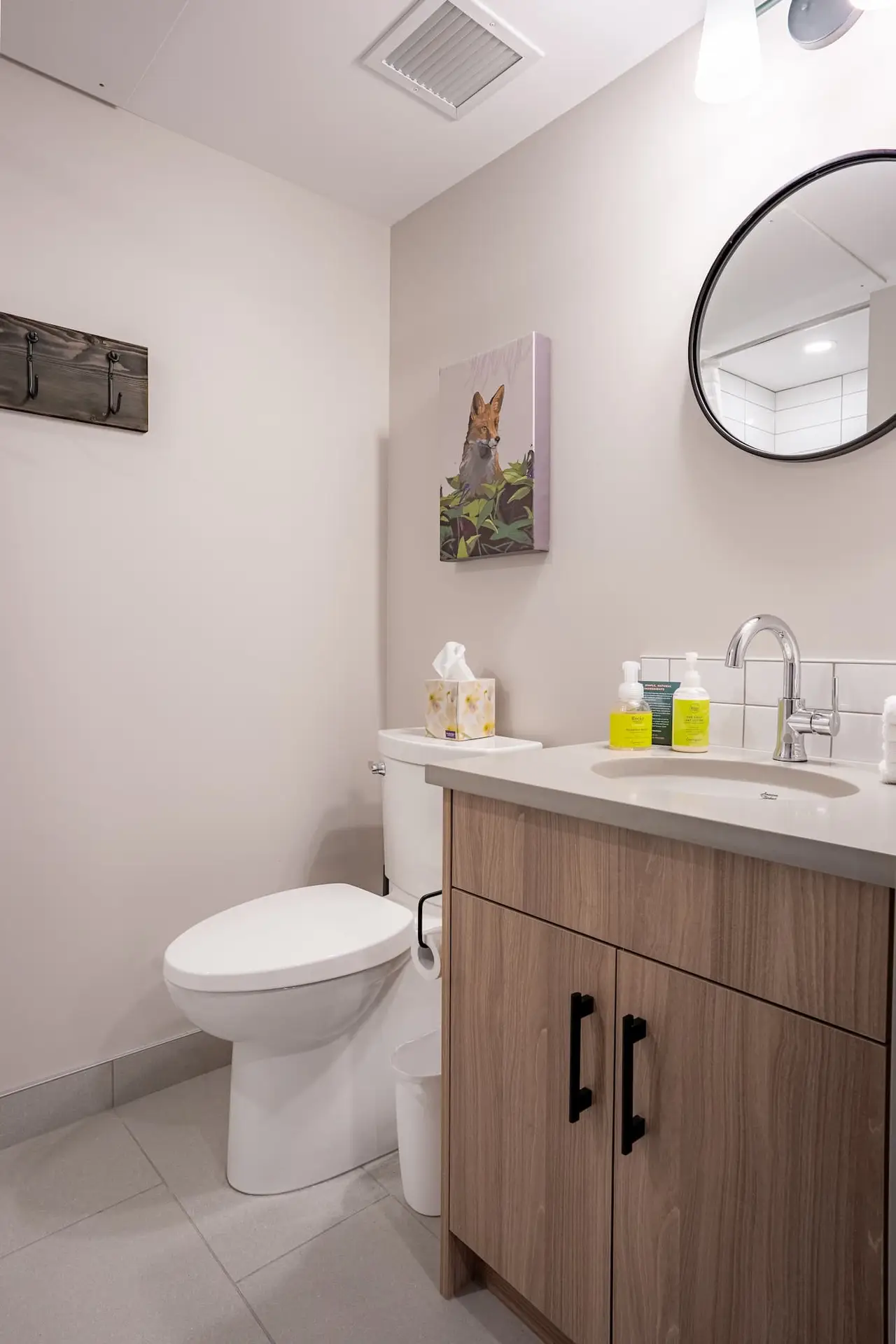 Modern bathroom in Basecamp Suites Banff one-bedroom suite with vanity, toilet, and fox art.