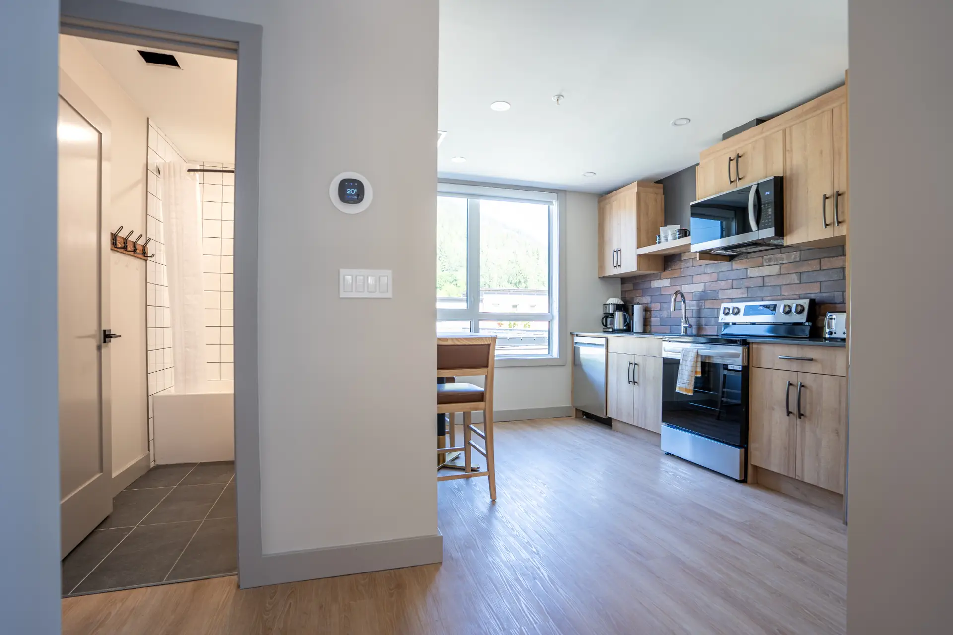 Modern one-bedroom king suite kitchen and bathroom at Basecamp Suites Revelstoke.