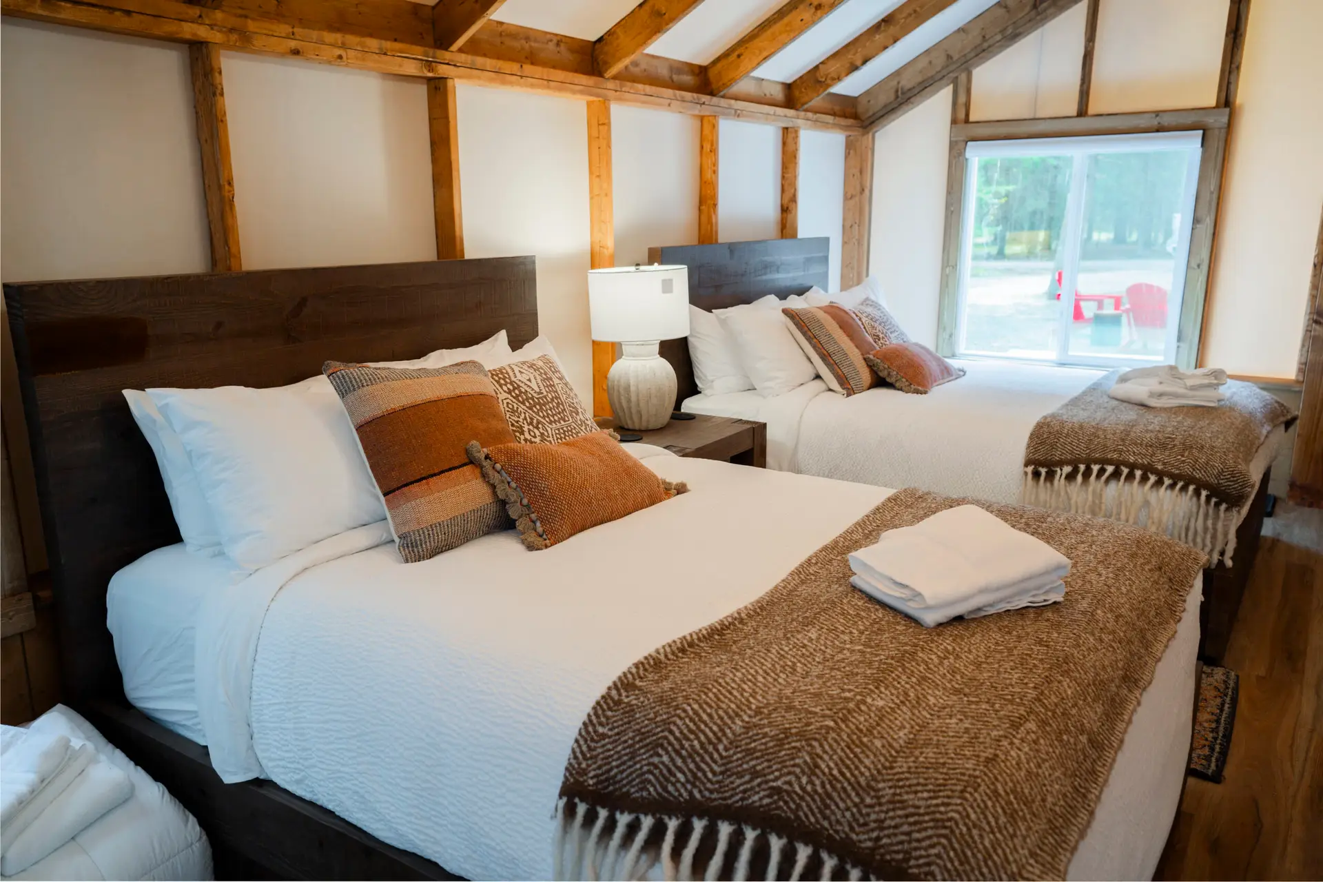 Interior of a Basecamp Sundance family tent with two beds and wooden beams.