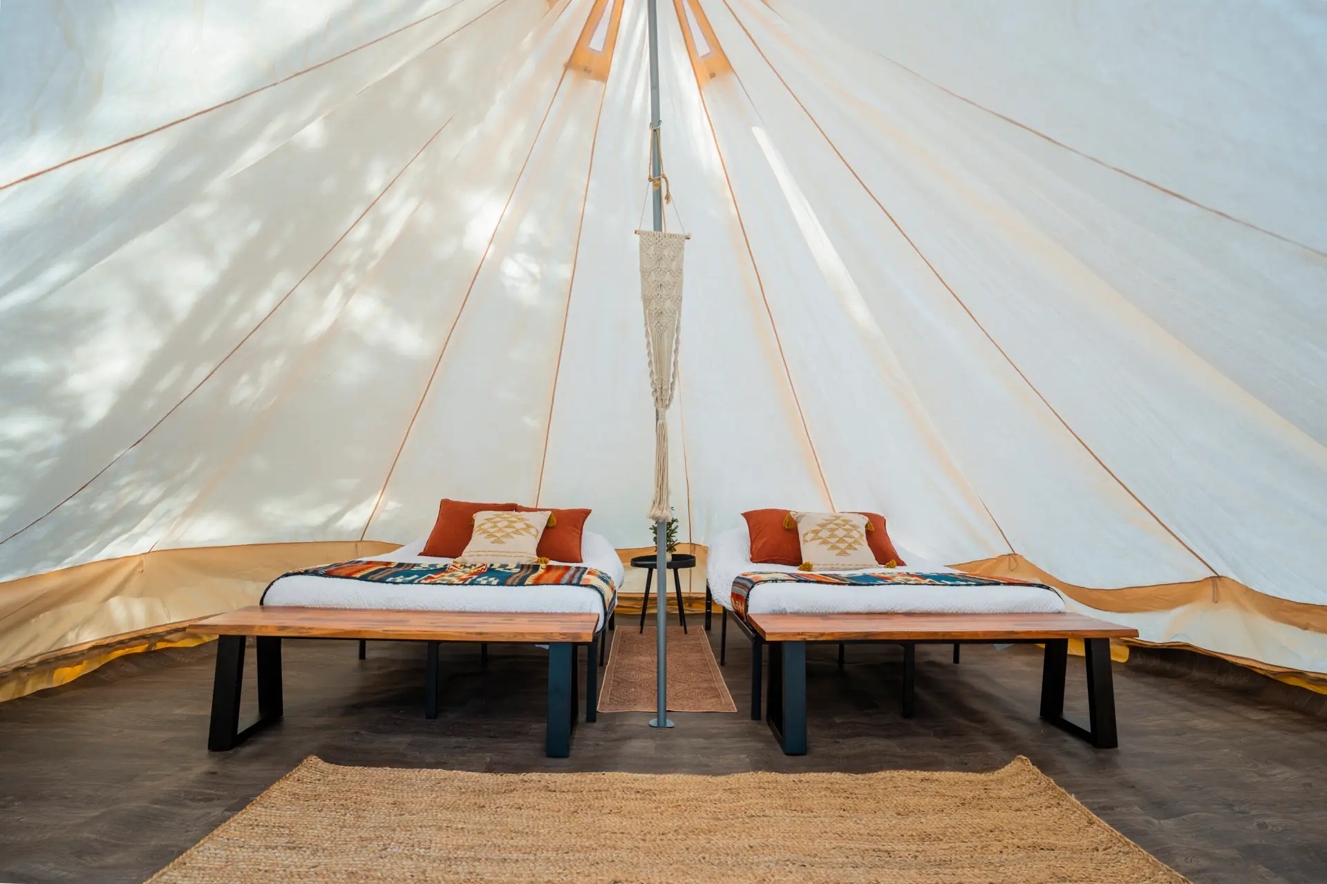 Interior of a spacious glamping canvas tent with two beds at Basecamp Sundance.