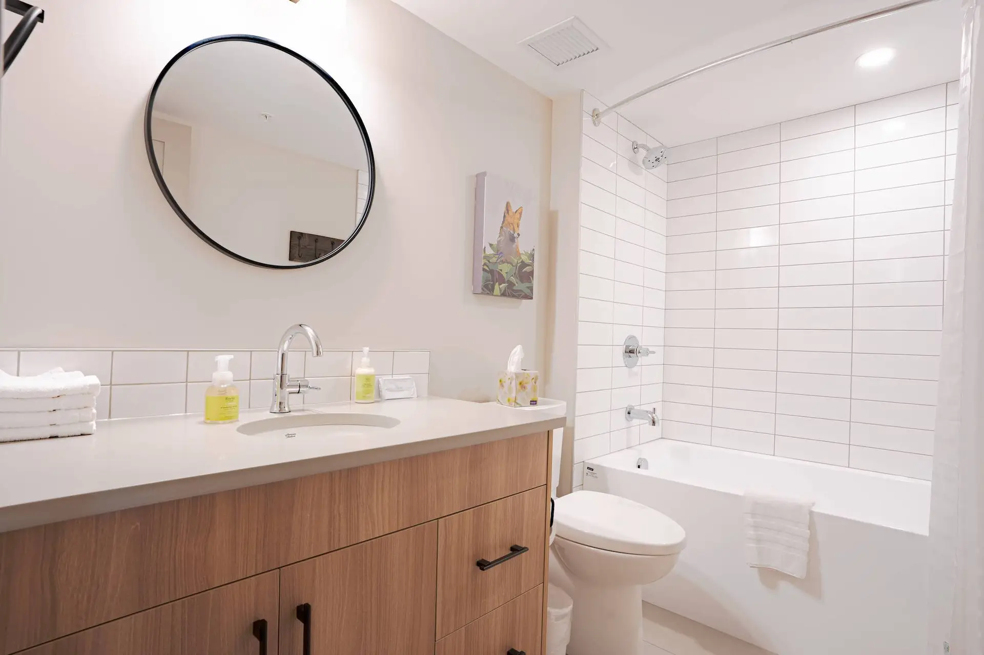 Modern bathroom with white subway tile shower, bathtub, and vanity in Basecamp Suites Banff.