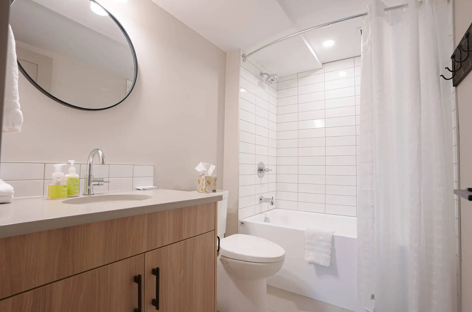 Modern bathroom in Basecamp Suites Banff with white subway tile shower, vanity, and toilet.