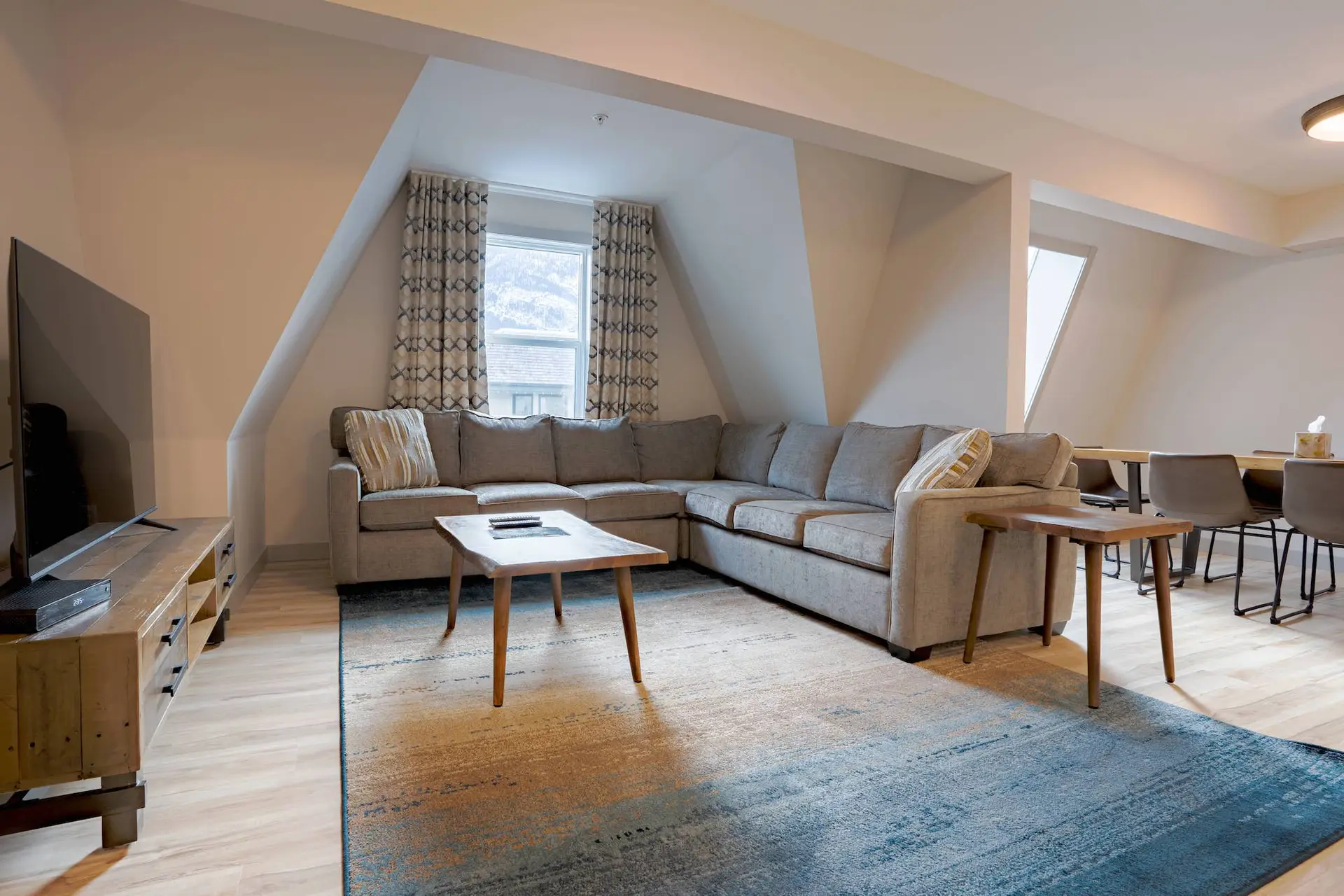 Basecamp Suites Banff: Living room with sectional sofa, coffee table, and rug.