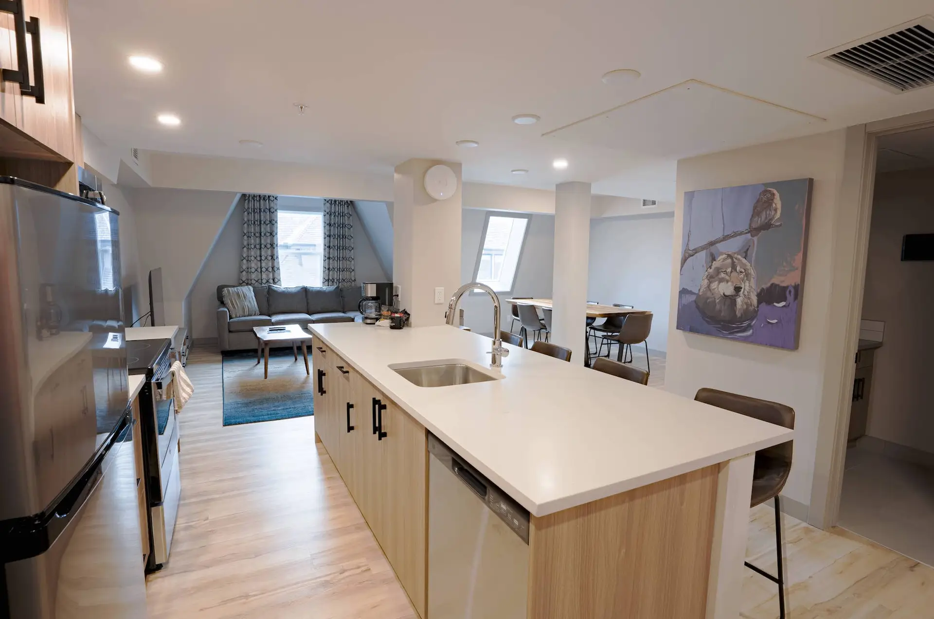 Modern kitchen island with sink and dishwasher in Basecamp Suites Banff three-bedroom suite.