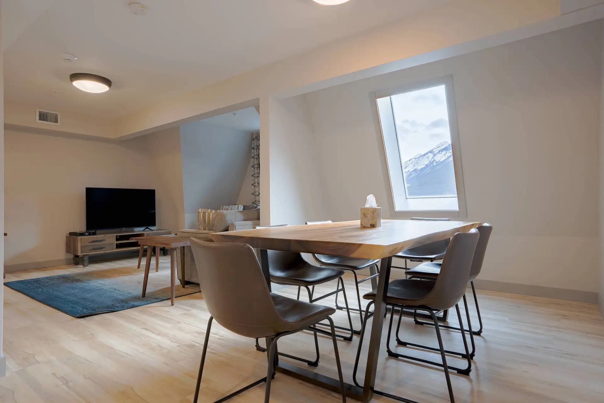 Dining area in Basecamp Suites Banff Superior Three Bedroom Suite with modern table and chairs.