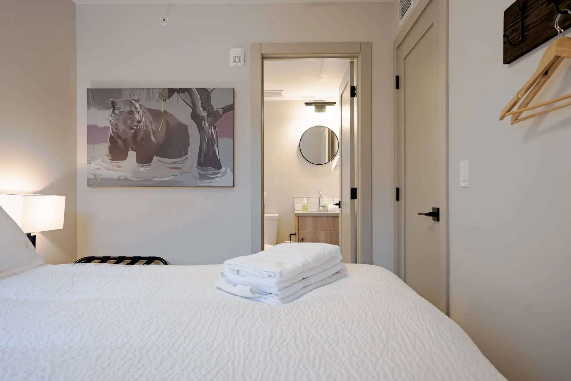 Basecamp Suites Banff: Two bedroom suite with king bed, painting, and bathroom view.