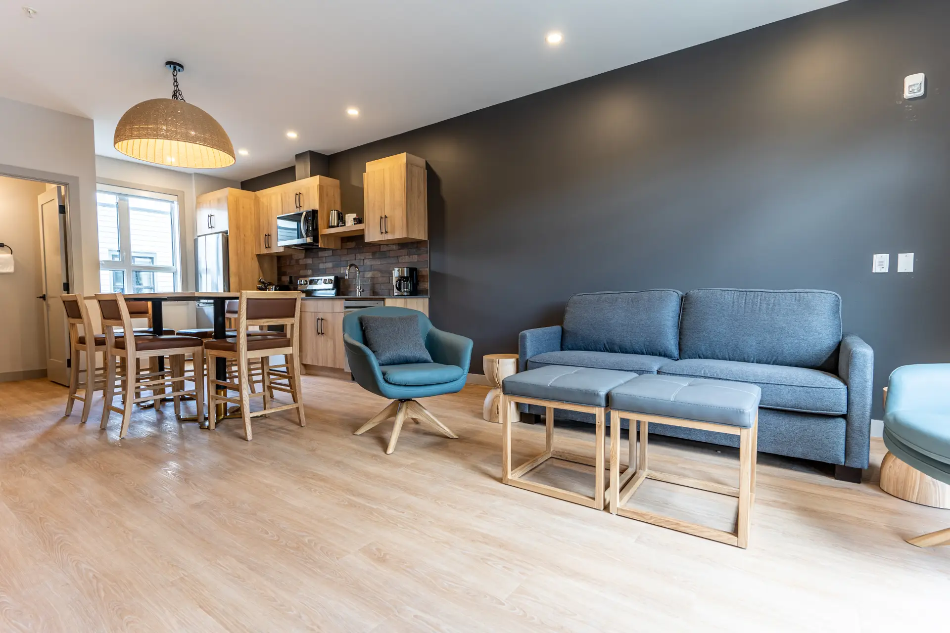 Modern living area and kitchen in a Basecamp Suites Revelstoke two-bedroom suite.