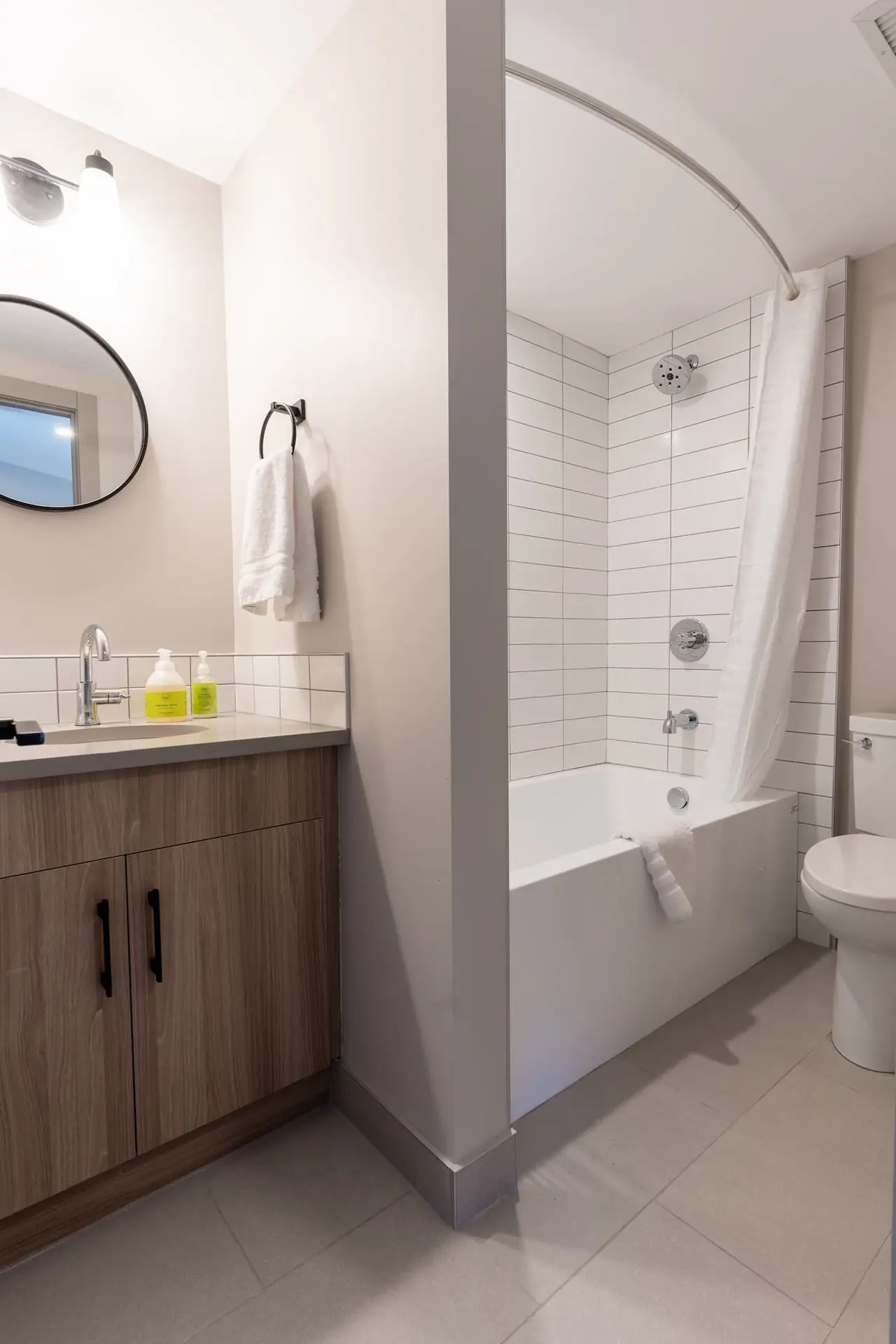 Modern bathroom with vanity, shower-tub combo, and toilet in Basecamp Suites Banff.