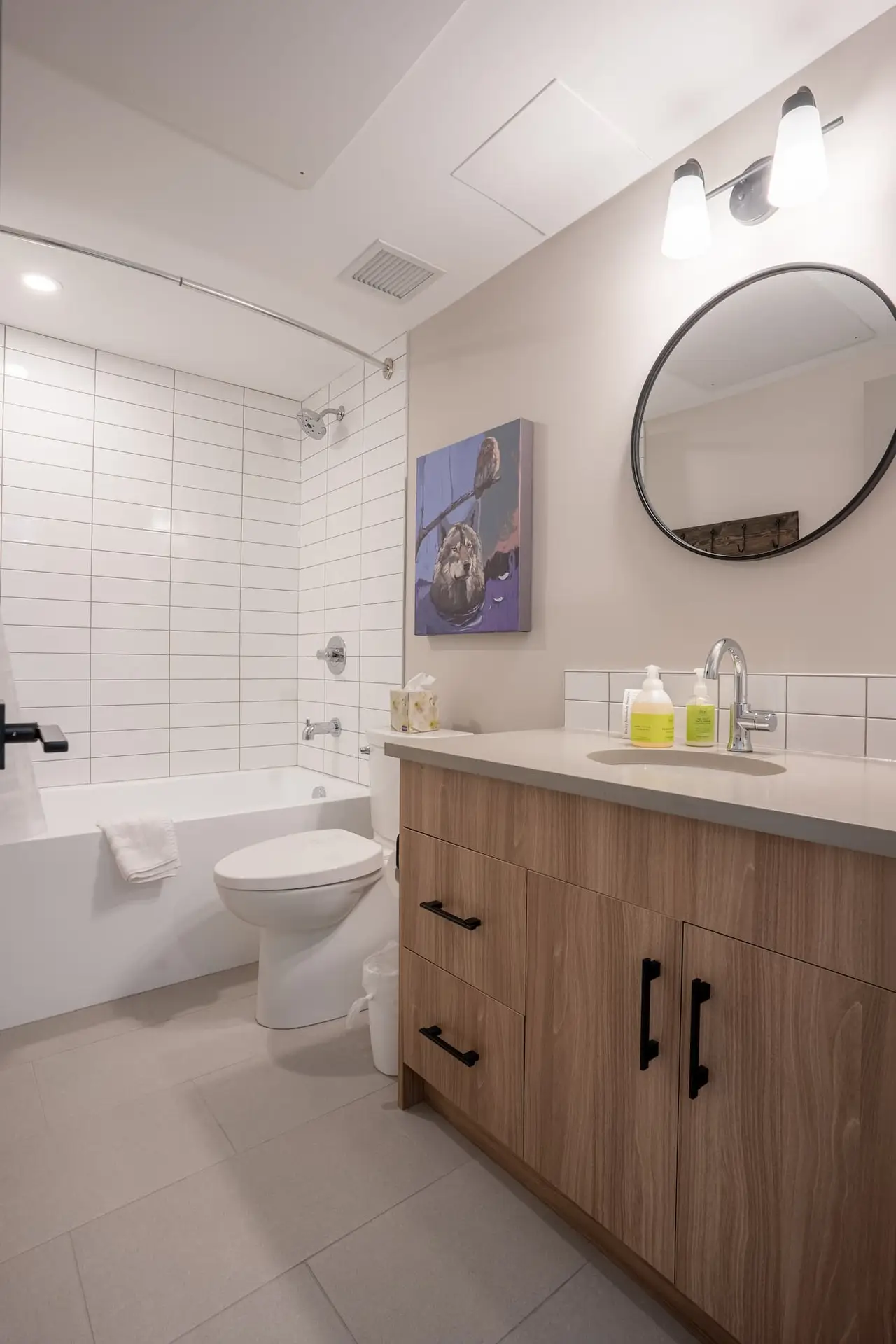 Modern bathroom in Basecamp Suites Banff three-bedroom suite with white tiled shower and vanity.
