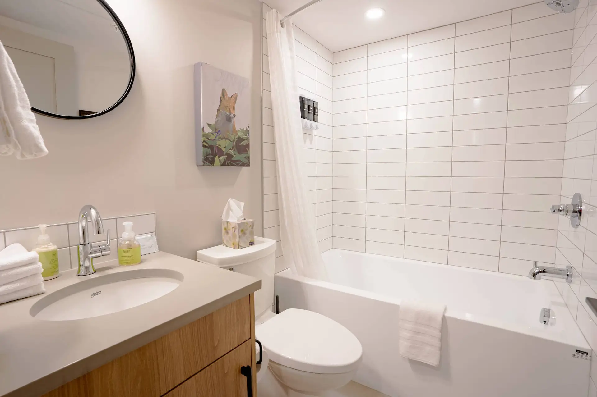 Modern bathroom in Basecamp Suites Banff Two Bedroom Suite with white subway tile, vanity, and tub.