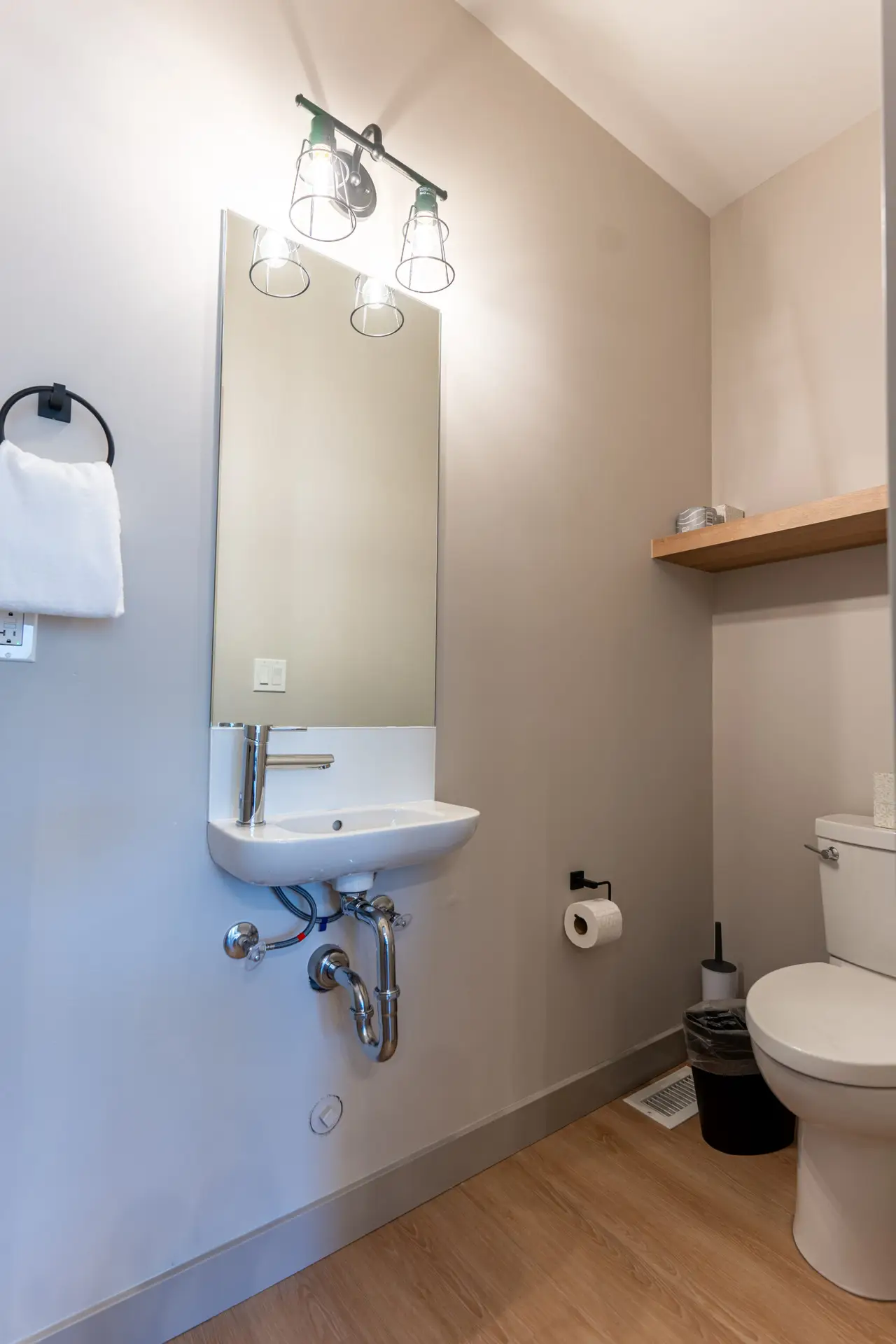 Modern bathroom with sink, toilet, and towel rack in Basecamp Suites Revelstoke