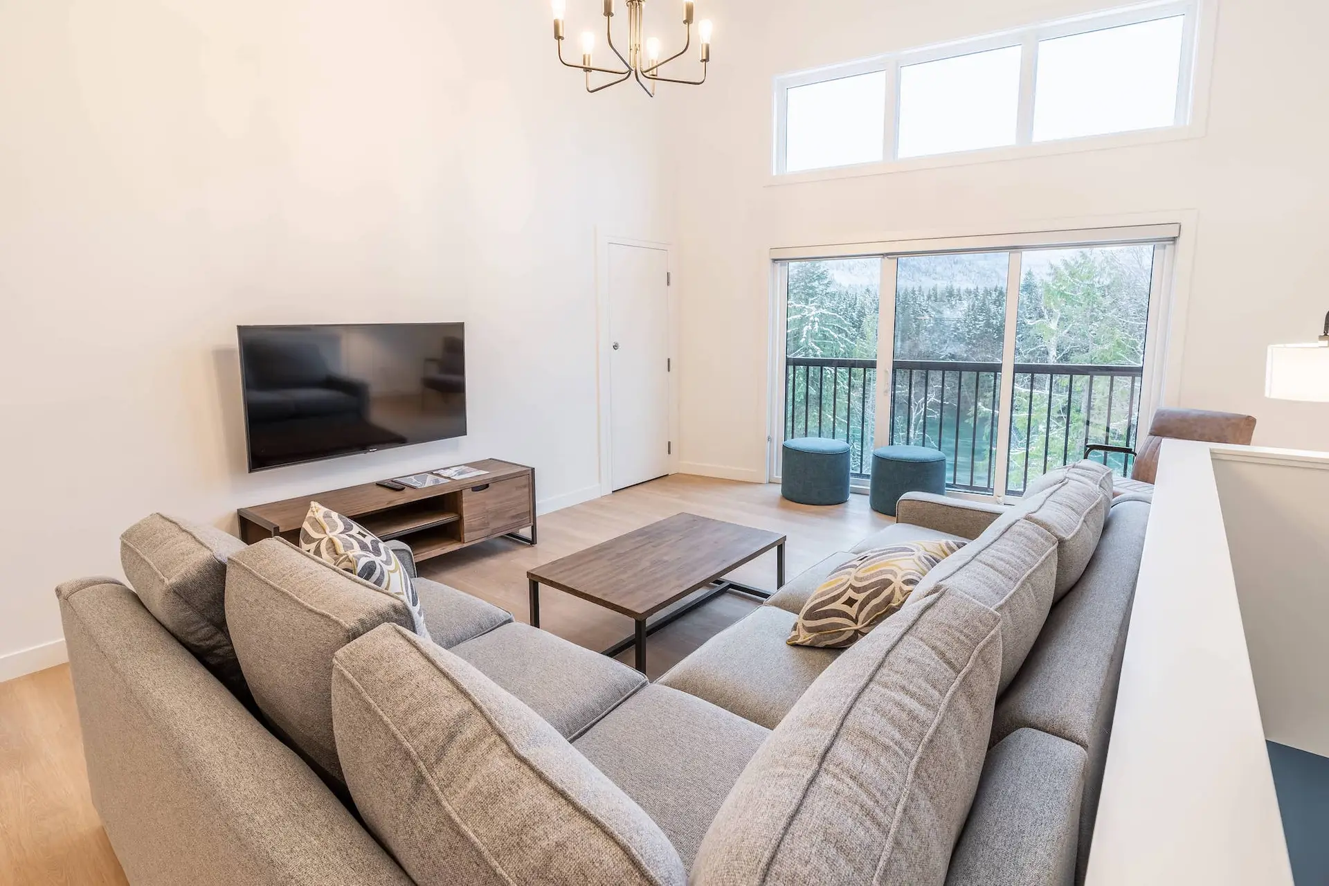 Living room of a Basecamp Resorts Revelstoke two-bedroom suite with large sectional sofa and mountain view.