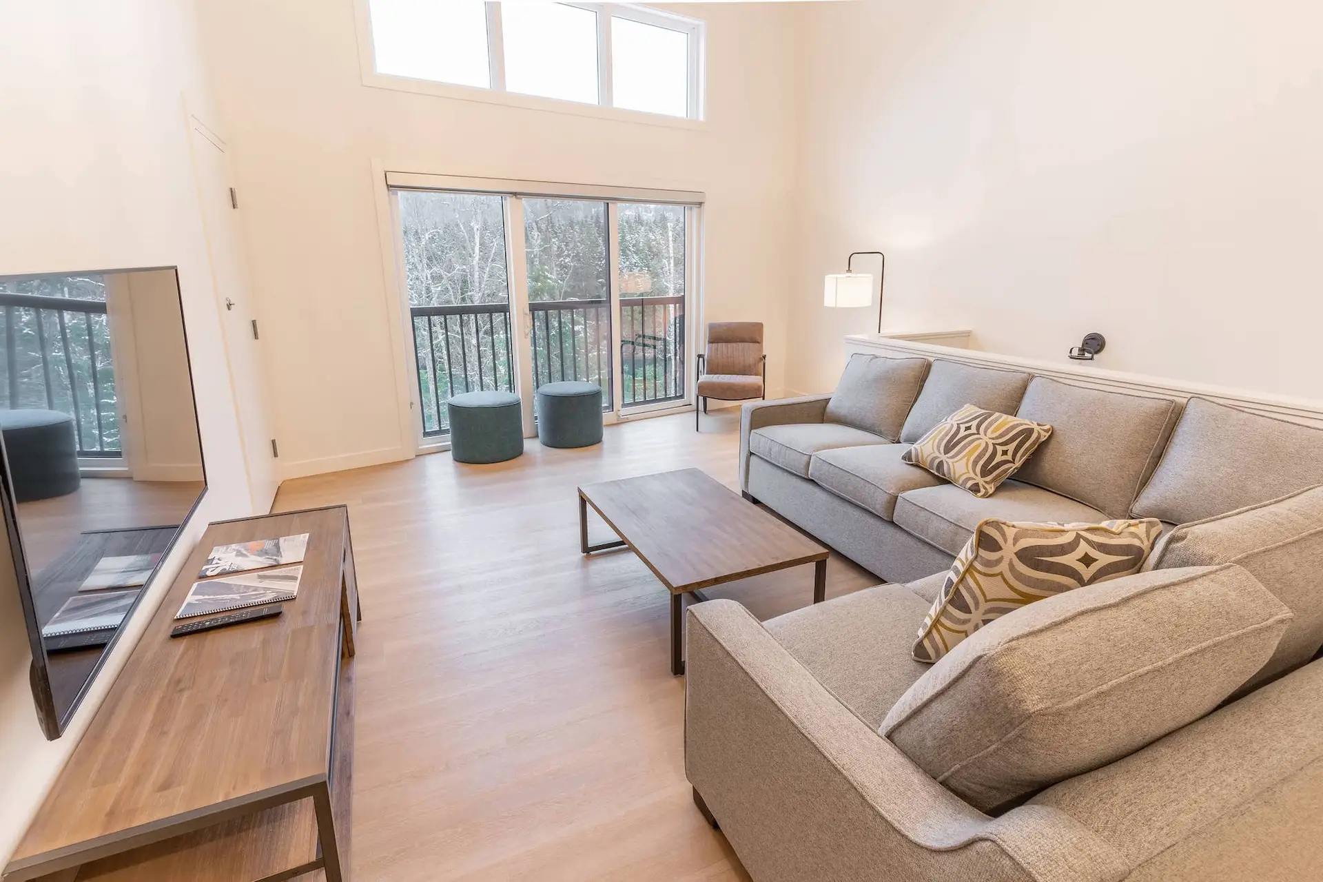 Revelstoke two bedroom suite living area with sectional sofa and balcony view