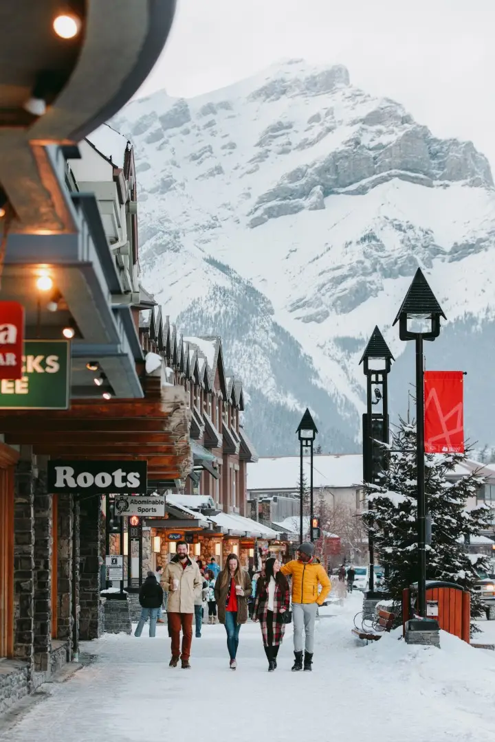 Banff street scene with snow, shops, and mountains