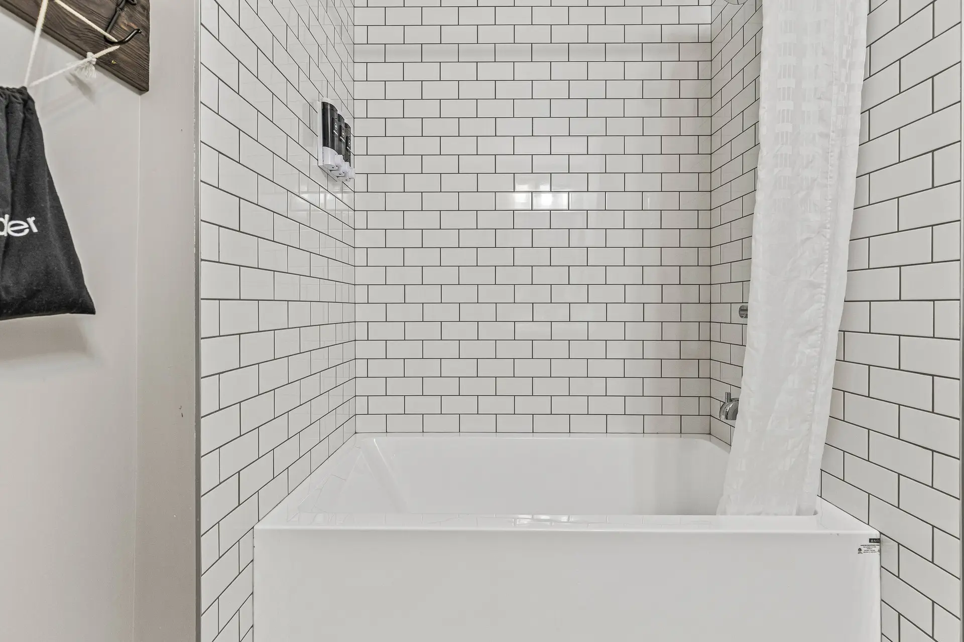 Deluxe Double Queen Room bathtub with white subway tile shower