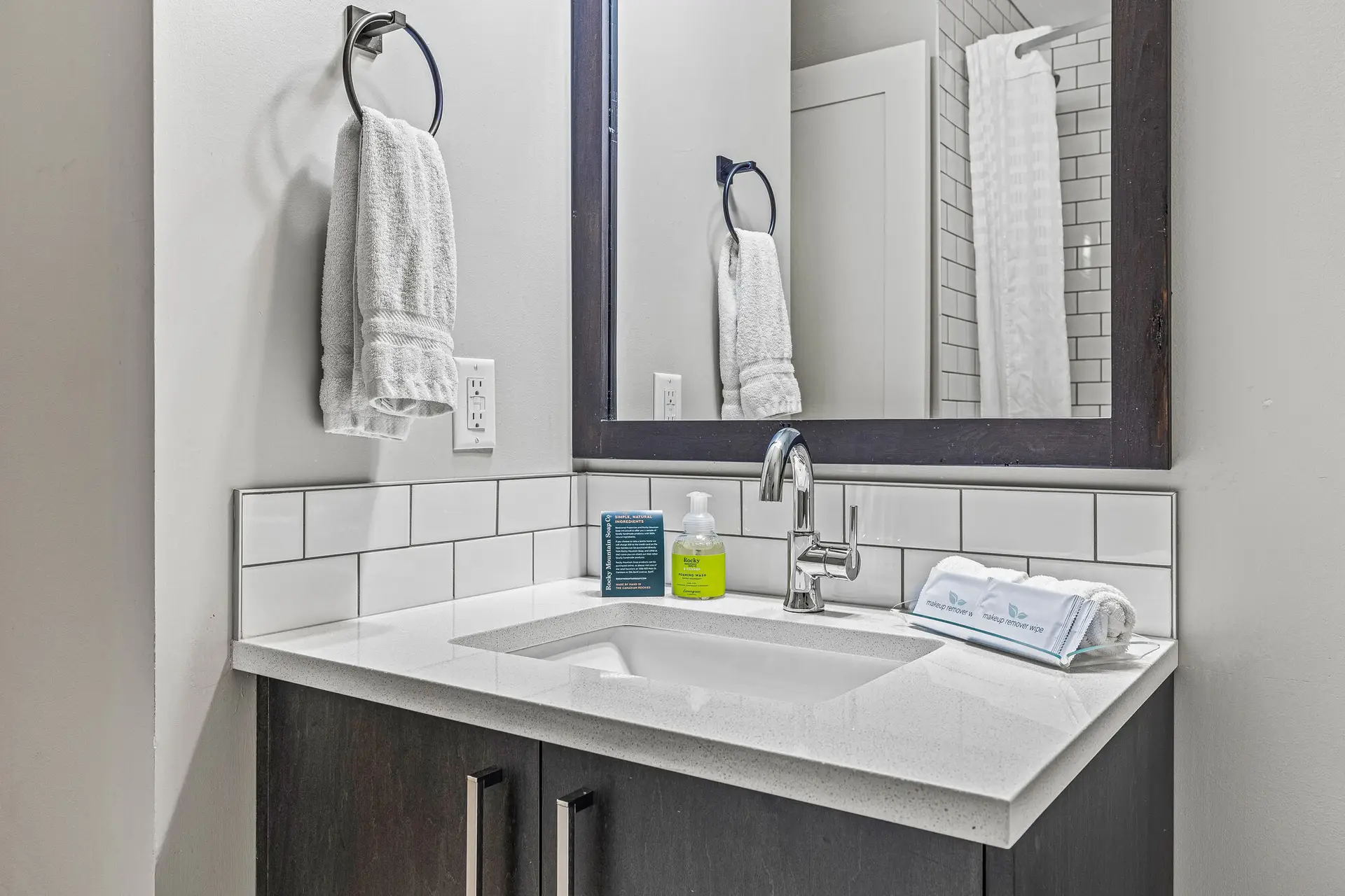 Deluxe double queen room bathroom at Basecamp Northwinds Canmore, featuring a modern vanity and sink.