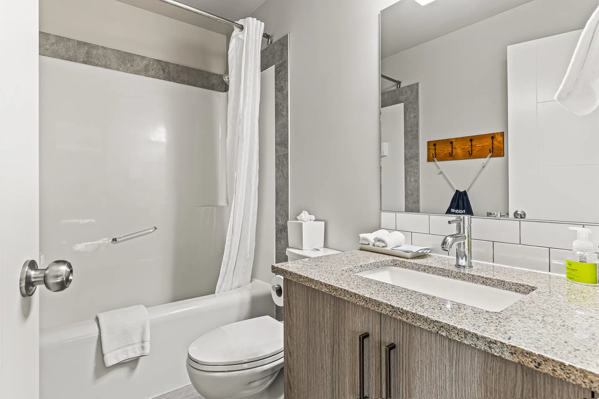 Deluxe Double Queen room bathroom at Basecamp Lodge Canmore with bathtub, toilet, and vanity.