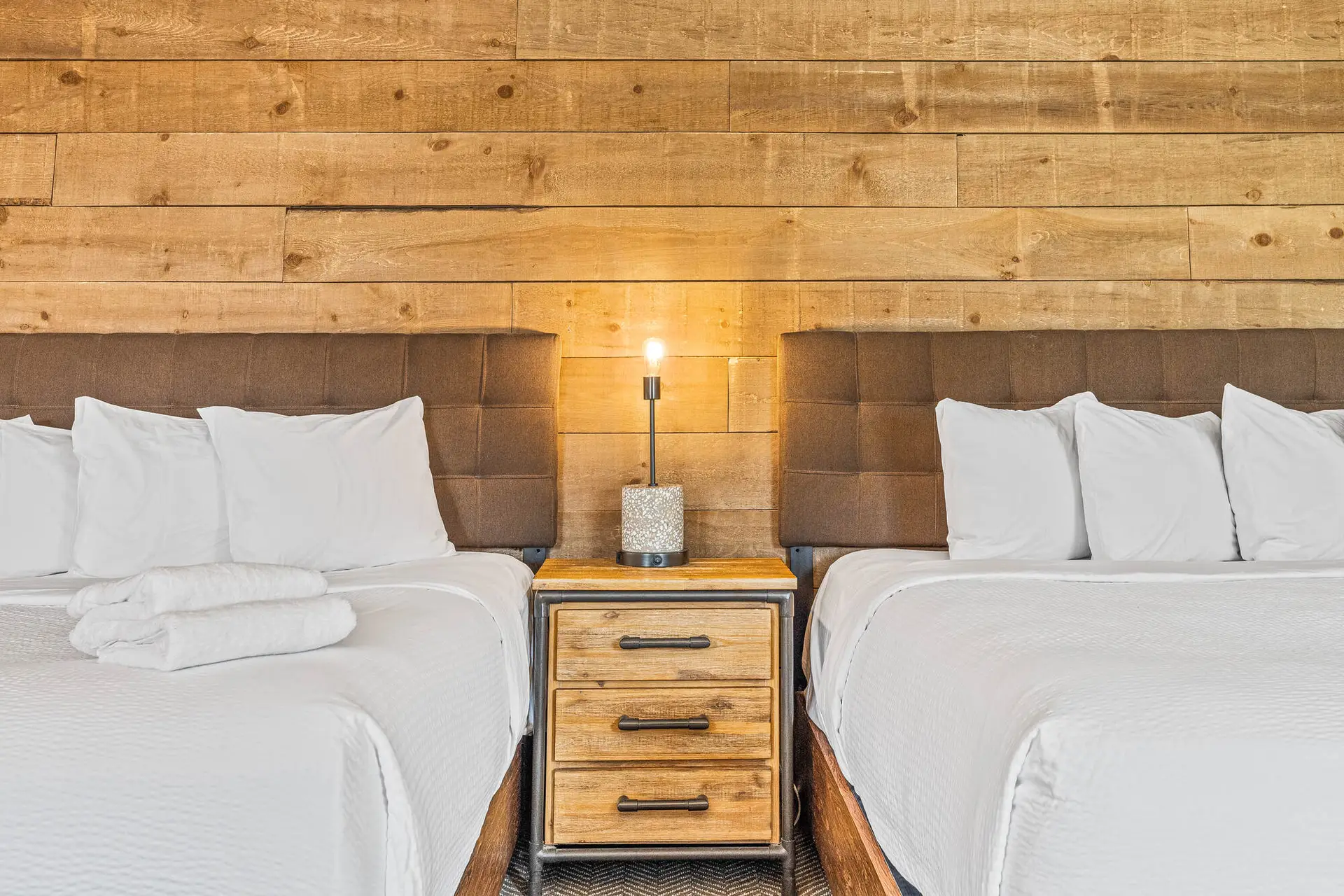 Deluxe double king room at Basecamp Lodge Canmore with wood accents and two beds.