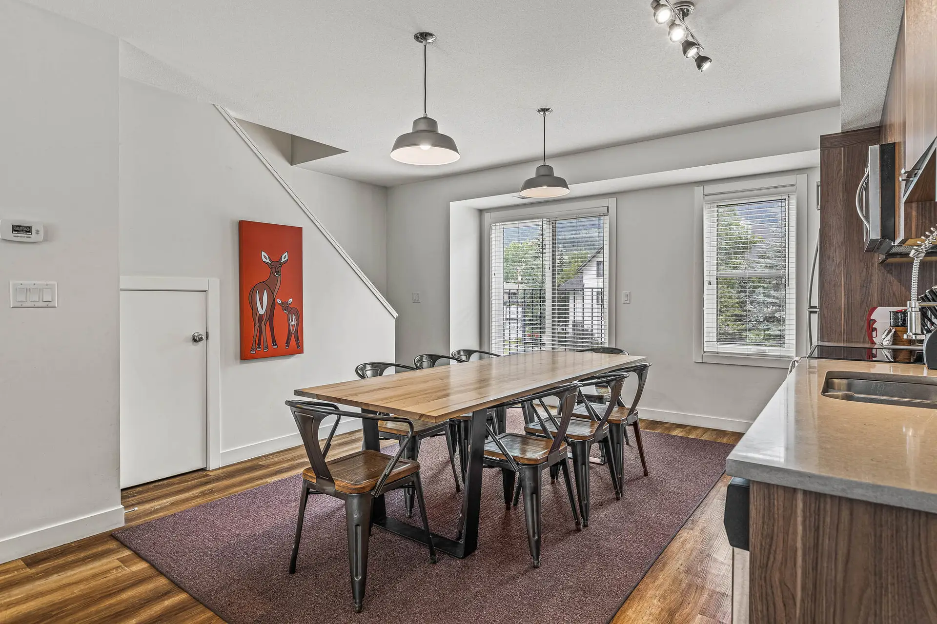 Dining area in a Basecamp Resorts Canmore three-bedroom suite with a table and chairs.
