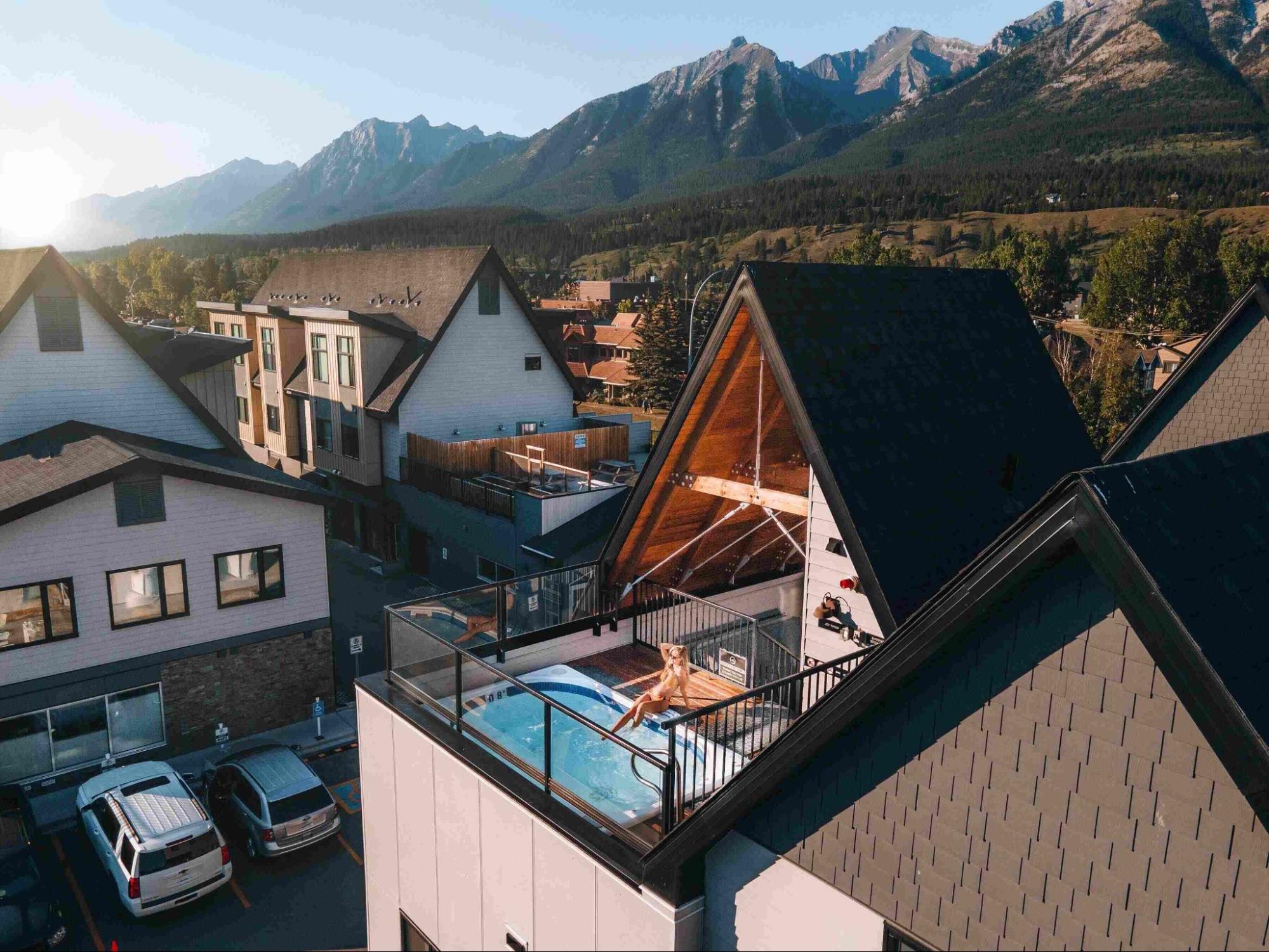 Woman relaxing in a rooftop hot tub with mountain views near Banff