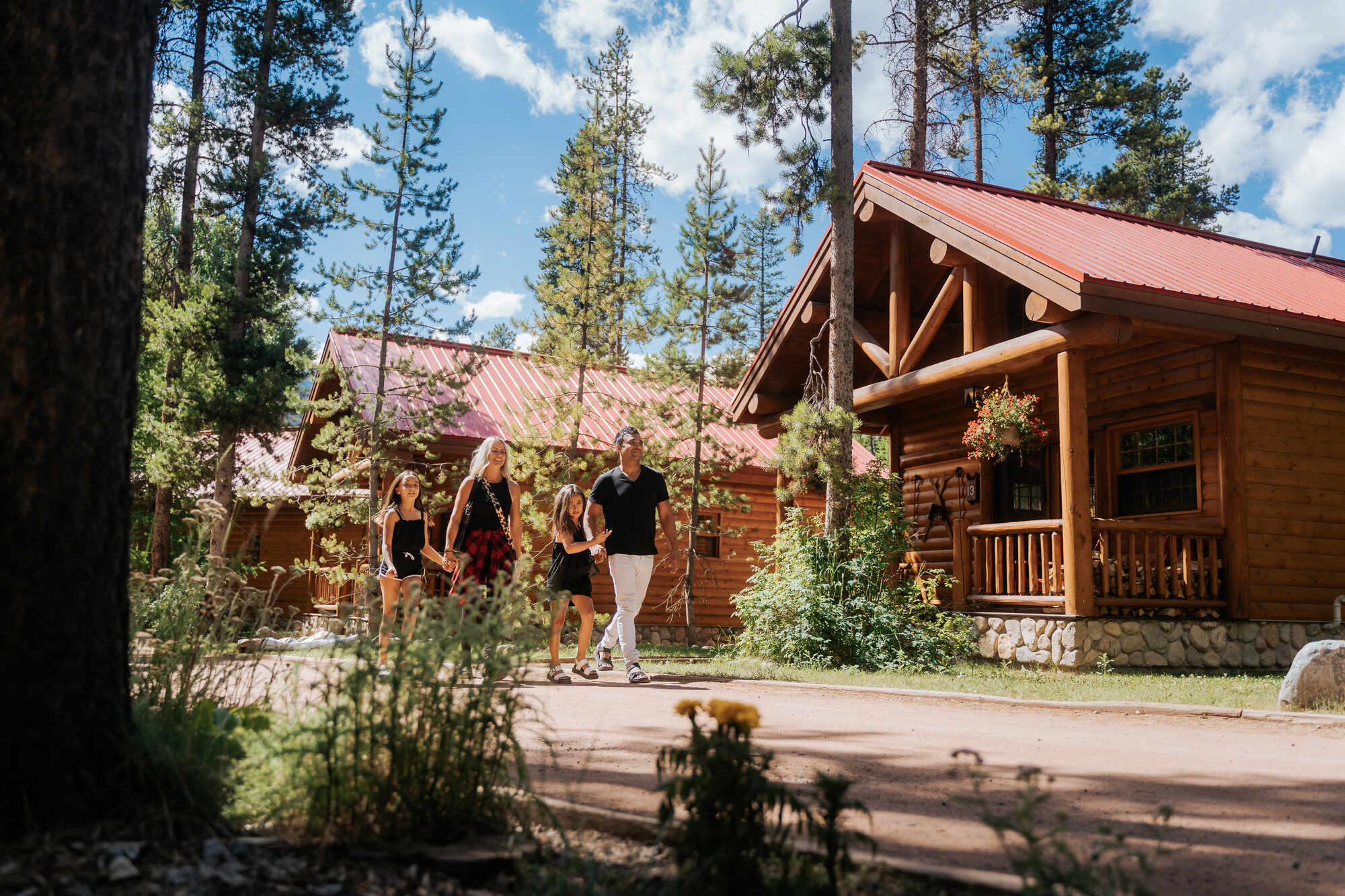 Family walking on path between log cabins in Canadian Rockies