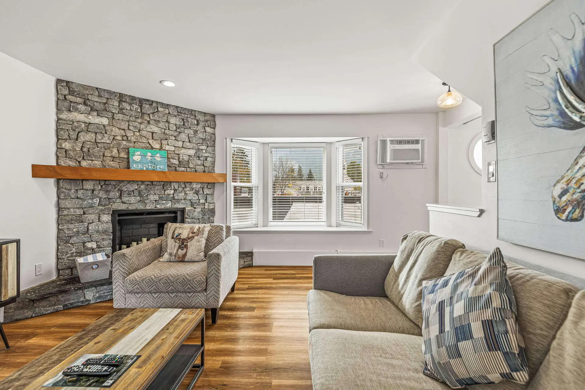 Basecamp Lamphouse Canmore living room with stone fireplace and bay window