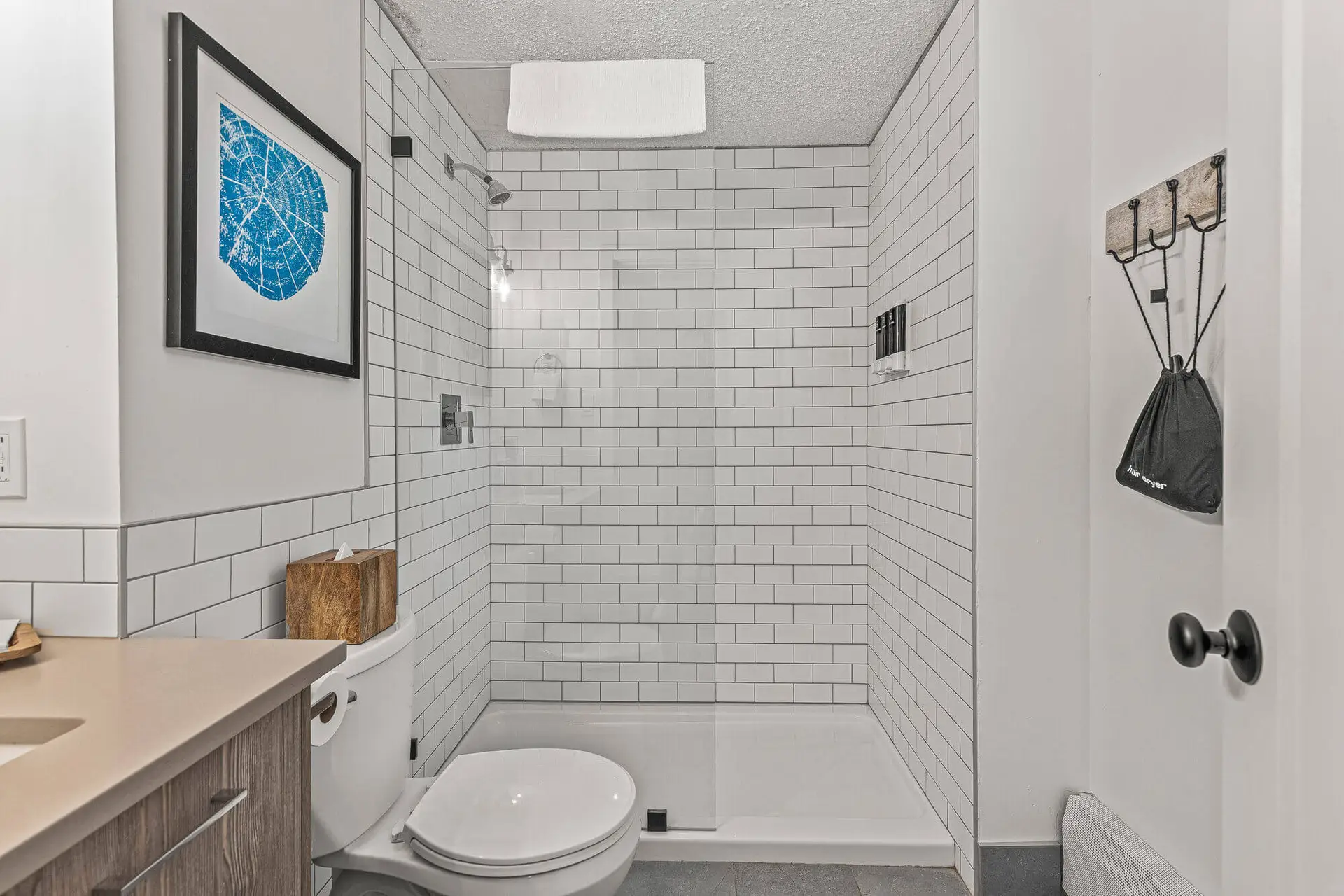 Modern bathroom with subway tile shower and blue map art