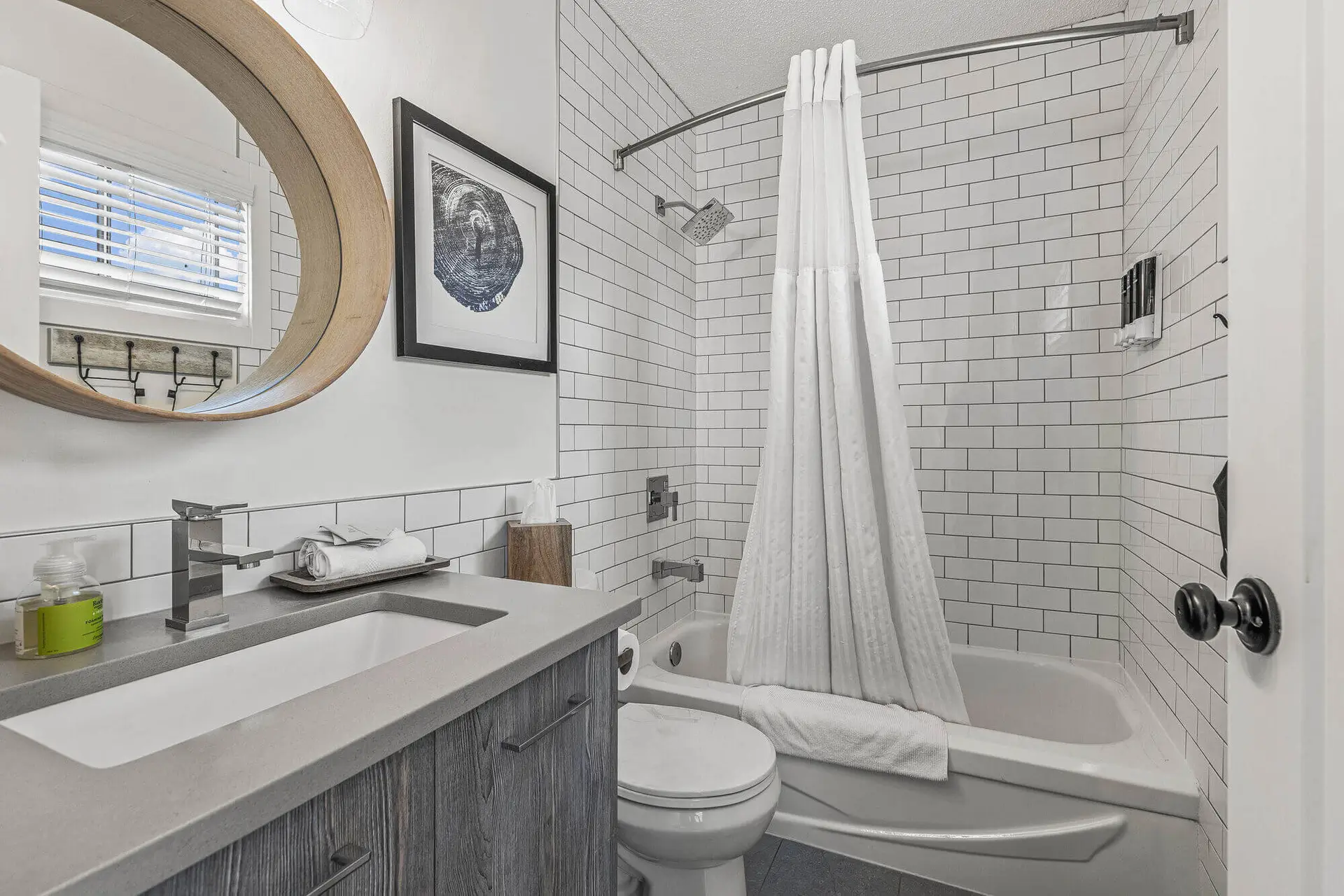 Modern bathroom with subway tile, vanity, toilet, and shower/tub combo