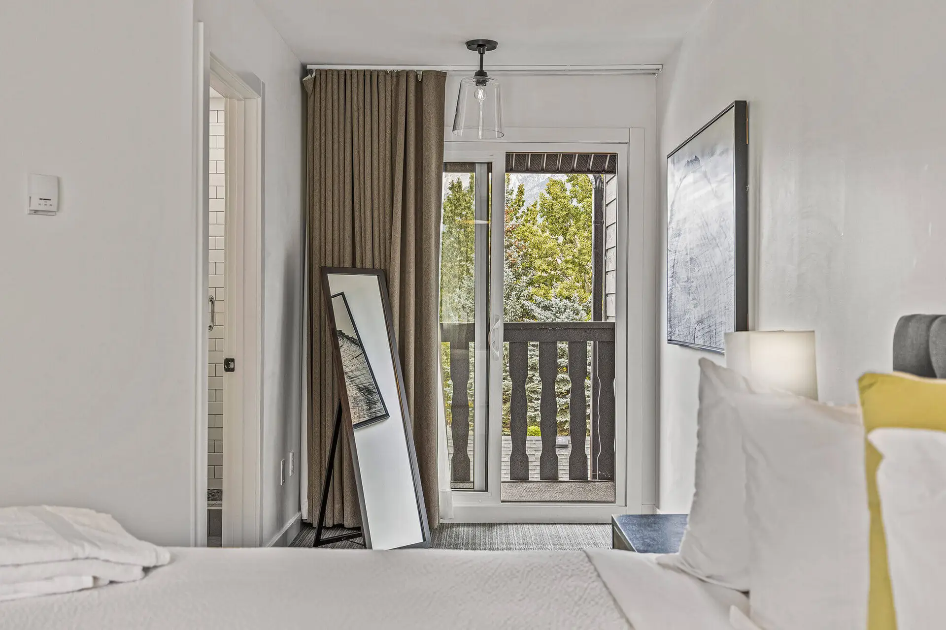 Lamphouse Apartment Canmore: Bedroom with balcony view and mirror